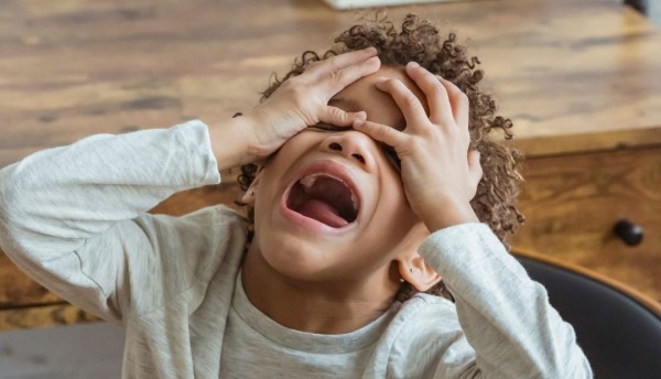 Mujer tira de un codazo a un niño de una moto y casi lo atropella un carro